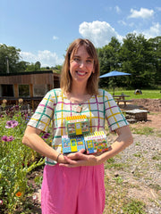 A girl holding the house matchboxes in a garden