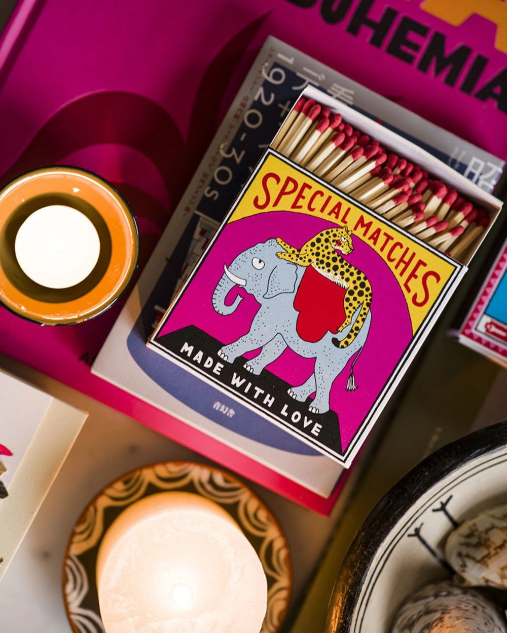 Kutija šibica Elephant and Cheetah na stolu uz svijeću