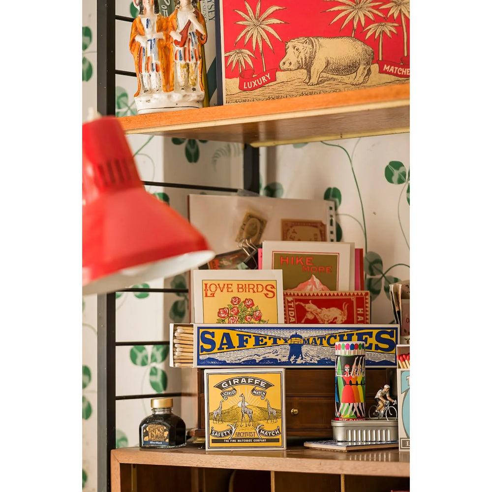 Archivist šibice Giraffe na polici
