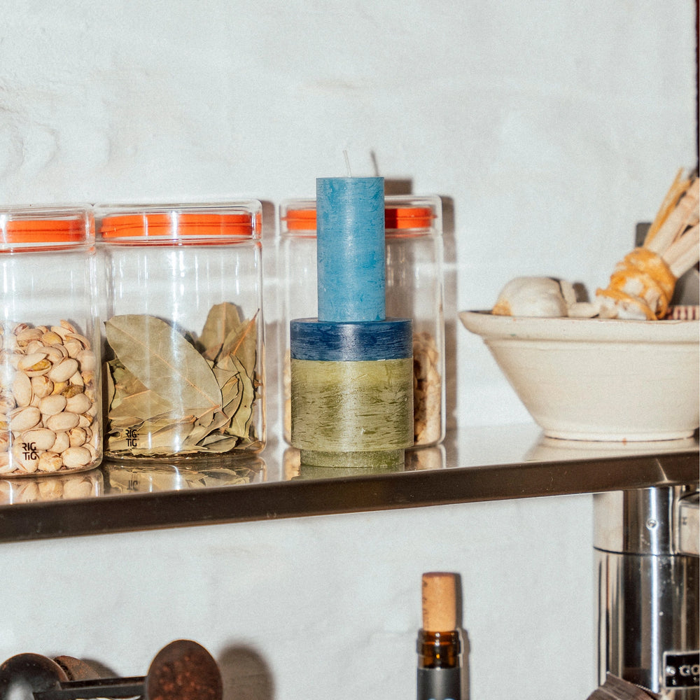 Stack 02 Green candle assembled on a shelf next to jars and bowls